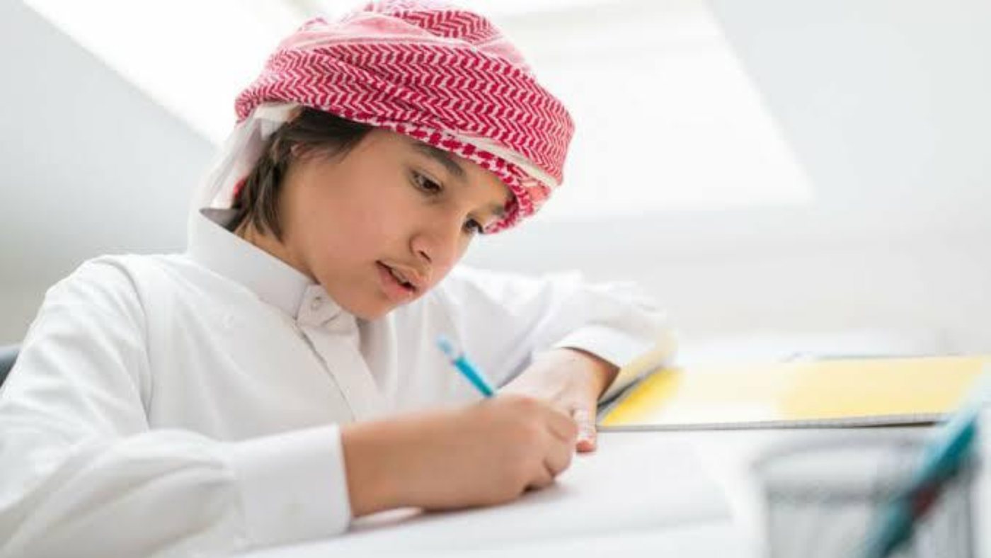 A student writing notes during a lesson